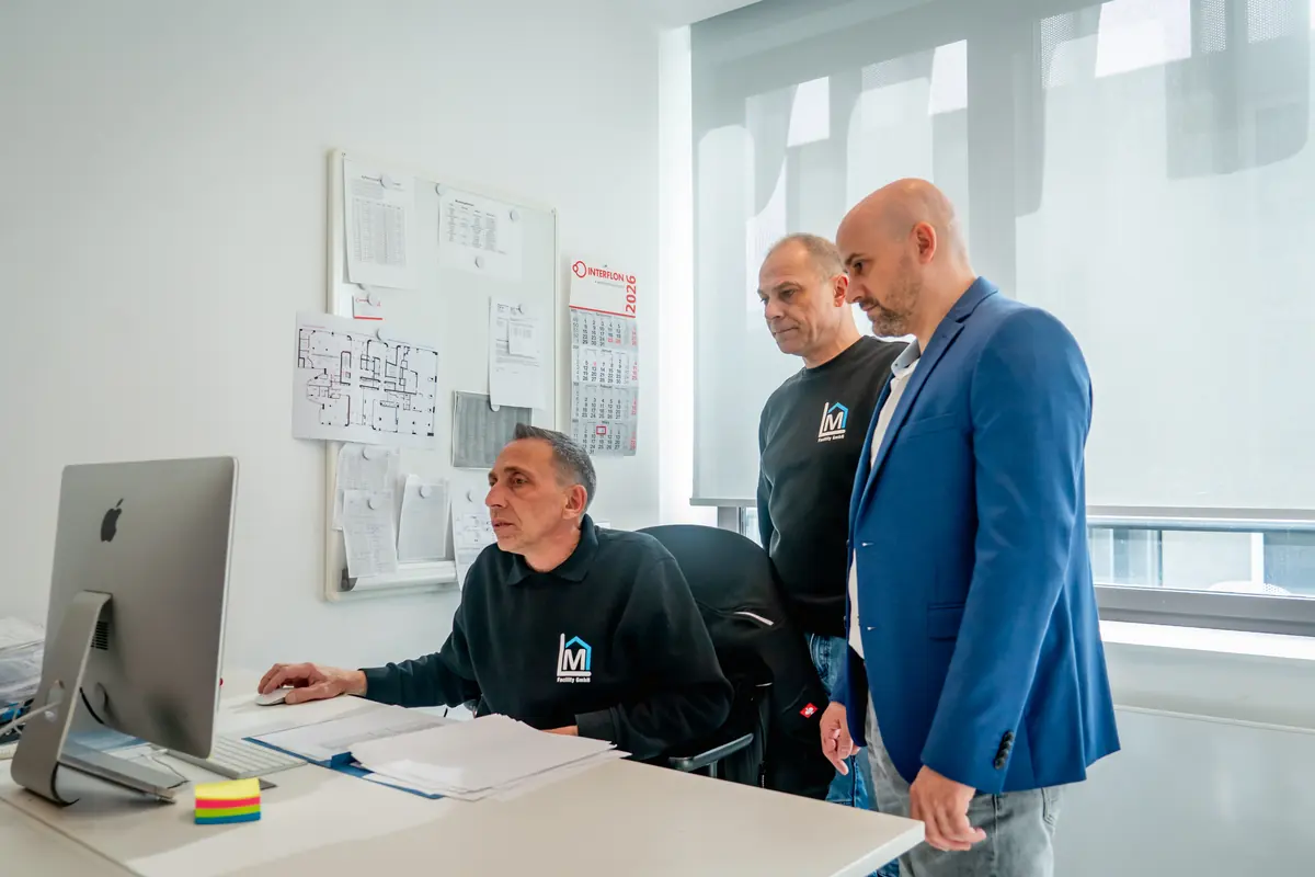 Planung technischer Maßnahmen: Mitarbeiter von ML Facility arbeiten gemeinsam am Rechner im Büro